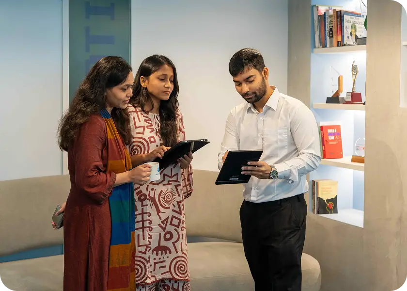 Three colleagues reviewing a design on tablets in the studio
